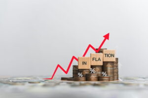 Wooden block and the word inflation on coins